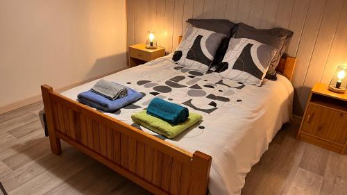 a bedroom with a bed with two towels on it at La Parenthèse in Longchaumois