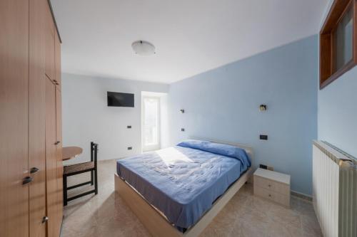 ein Schlafzimmer mit einem Bett mit blauen Laken und einem Waschbecken in der Unterkunft Casa vacanze Casalena 