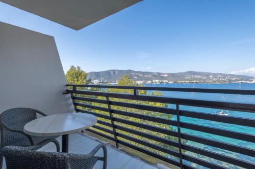 a balcony with a table and chairs and a view of the water at Leonardo Royal Hotel Mallorca Palmanova Bay in Palmanova