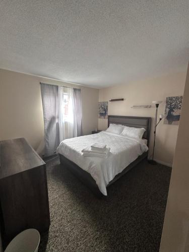 a bedroom with a large white bed and a window at Maddy's Place in Oshawa