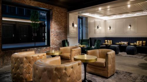 a restaurant with chairs and tables and a brick wall at Arthouse Hotel in New York