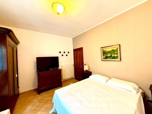 una camera da letto con un letto e una TV a schermo piatto di Villa Lilly - 20 min da Maranello a Serramazzoni