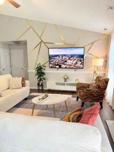 a living room with a flat screen tv on the wall at Queen City family-friendly entire house, Charlotte in Charlotte