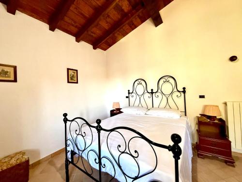 una camera da letto con un letto nero con lenzuola bianche di Villa Lilly - 20 min da Maranello a Serramazzoni