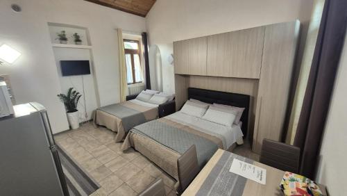 une petite chambre avec deux lits et une table dans l'établissement Corte Malpensa, à Somma Lombardo