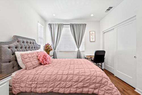 ein Schlafzimmer mit einem rosa Bett mit einer rosa Bettdecke in der Unterkunft Central Location Cozy Private Bedroom w Bathroom in Irvine