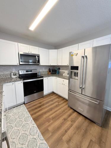 a kitchen with white cabinets and stainless steel appliances at Queen City family-friendly entire house, Charlotte in Charlotte