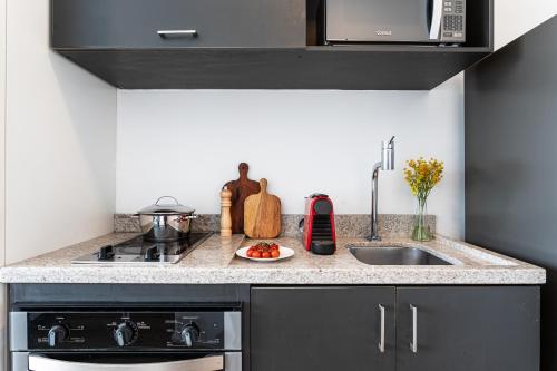 a kitchen with a sink and a stove at Setin Downtown Praca da Sé by Viva - Prédio completo com piscina perto de estação de metrô no Centro de São Paulo in Sao Paulo