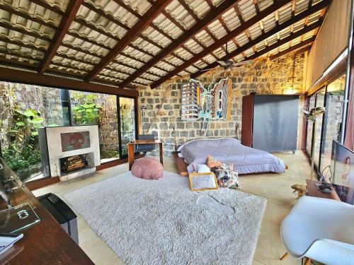 a living room with a bed and a fireplace at Mirante do Leo - Casa com Piscina Aquecida e Loft Exclusivo com Vista para o Mar in Ubatuba