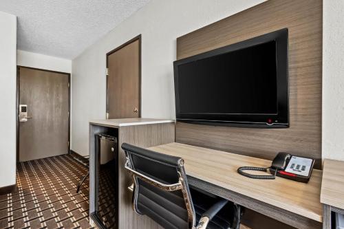 a hotel room with a desk with a television and a phone at Motel 6 North Sioux City, SD I 29 North in North Sioux City