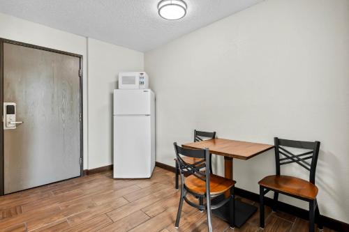 a kitchen with a table and a refrigerator and chairs at Motel 6 North Sioux City, SD I 29 North in North Sioux City