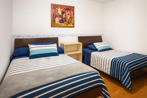 two beds sitting in a room with at Hotel El Molino in Facatativa