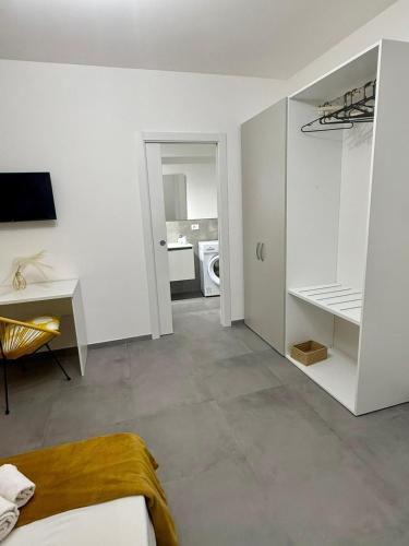 a white room with a bed and a desk at Novea Apartments - Comodi Appartamenti con Parcheggio & Wi-Fi vicino Taormina in Taormina