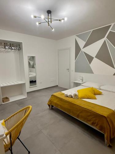 a bedroom with a large bed and a chair at Novea Apartments - Comodi Appartamenti con Parcheggio & Wi-Fi vicino Taormina in Taormina
