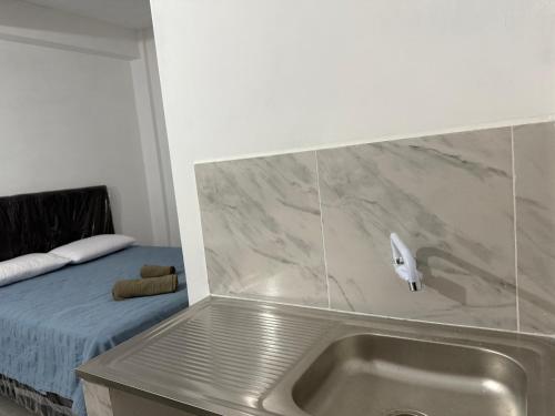 a kitchen with a sink next to a bed at Departamentos Imperial in Encarnación