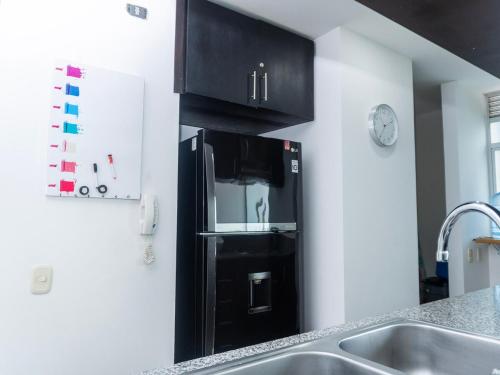 a black refrigerator in the corner of a kitchen at Apt Platinum Rodadero 9C in Estación El Salto