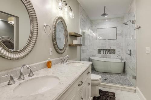 a bathroom with two sinks and a tub and a toilet at Modern Comfort Near Columbus Home with Yard and Porch in London