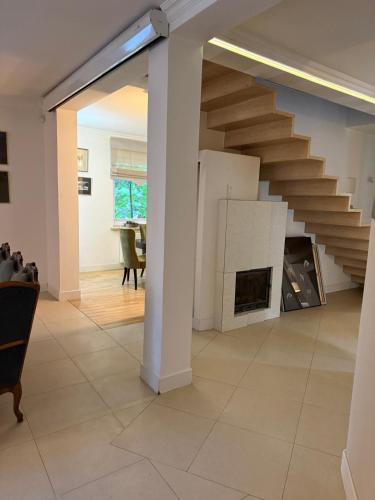 a living room with a staircase and a fireplace at WieloDom - kryjówka na wsi in Wielogóra