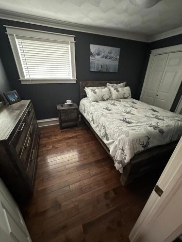 ein Schlafzimmer mit einem Bett und einem Fenster in der Unterkunft Executive Home in Timmins