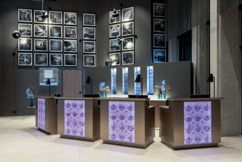 a bar in a room with pictures on the wall at Leonardo Royal Hotel Amsterdam in Amsterdam