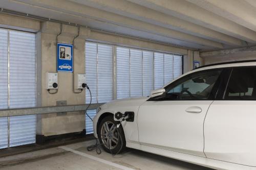 a white car is parked in a parking lot at Leonardo Royal Hotel Amsterdam in Amsterdam