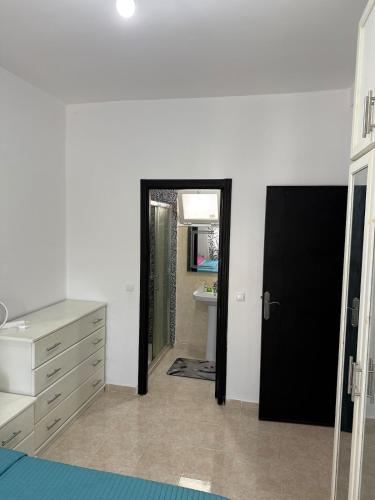 a bathroom with a black door and a sink at Appartement tangier airport in Hajreien