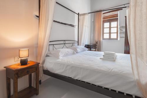 a bedroom with a bed and a lamp on a table at Katharsis Palace 15th Century Art Hotel at Naxos Old Town IV in Naxos Chora