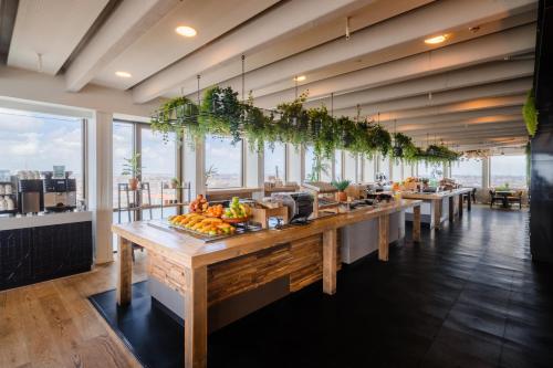 a restaurant with a long counter with fruit on it at Leonardo Hotel Amsterdam Rembrandtpark in Amsterdam