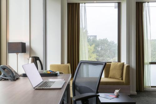 a room with a desk with a laptop and a chair at Leonardo Hotel Amsterdam Rembrandtpark in Amsterdam