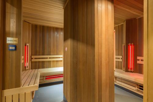 a room with two bunk beds and red curtains at Leonardo Hotel Amsterdam Rembrandtpark in Amsterdam