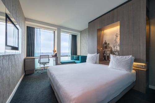 a hotel room with a large bed and a large window at Leonardo Hotel Amsterdam Rembrandtpark in Amsterdam