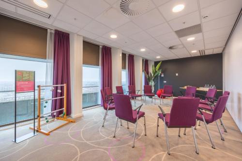 a conference room with purple chairs and a table at Leonardo Hotel Amsterdam Rembrandtpark in Amsterdam