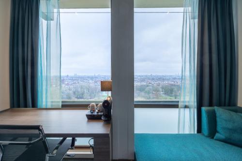 a room with a desk and a large window at Leonardo Hotel Amsterdam Rembrandtpark in Amsterdam