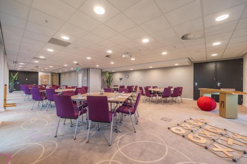 a conference room with tables and purple chairs at Leonardo Hotel Amsterdam Rembrandtpark in Amsterdam