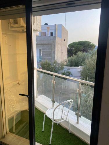 a balcony with a chair and a view of a building at Immobilier hammamet nord in Hammamet