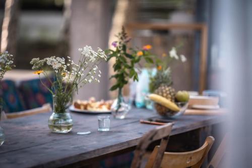 a wooden table with flowers in vases on it at WieloHome in Wielogóra