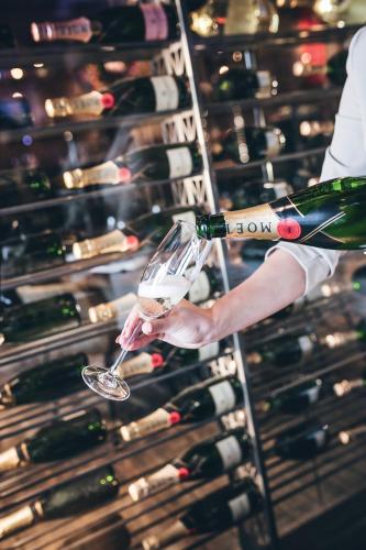a person holding a glass of wine in a wine cellar at Leonardo Hotel Vinkeveen Amsterdam in Vinkeveen