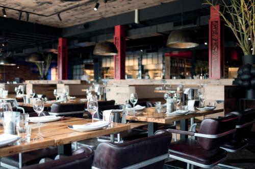 a restaurant with wooden tables and leather chairs at Leonardo Hotel Vinkeveen Amsterdam in Vinkeveen