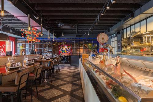a restaurant with wooden tables and chairs and a counter at Leonardo Hotel Vinkeveen Amsterdam in Vinkeveen