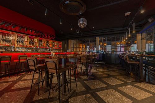 a bar with chairs and tables in a room at Leonardo Hotel Vinkeveen Amsterdam in Vinkeveen