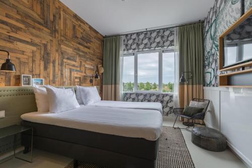 a hotel room with a bed and a chair at Leonardo Hotel Vinkeveen Amsterdam in Vinkeveen