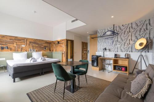 a bedroom with a bed and a living room at Leonardo Hotel Vinkeveen Amsterdam in Vinkeveen