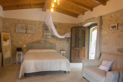 a bedroom with a bed and a couch and a window at Dimora del Capriolo in San Donato Val di Comino