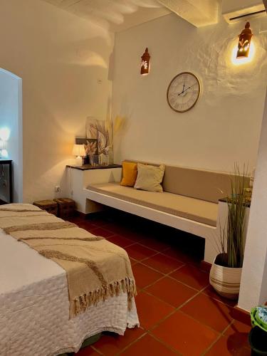a living room with two beds and a clock on the wall at Casa Almaraz in Reguengos de Monsaraz