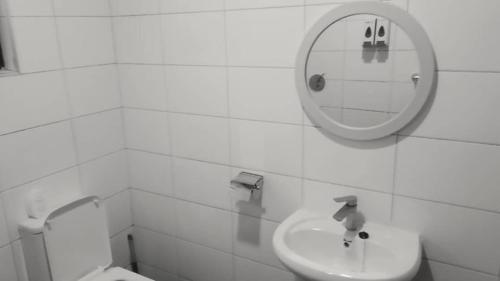 a bathroom with a sink and a mirror and a toilet at Guesthouse in Lusaka