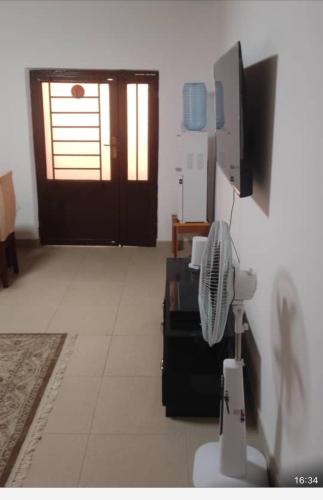 a living room with a fan and a door at Guesthouse in Lusaka