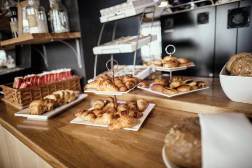 a counter with a bunch of pastries on display at Leonardo Hotel Lelystad City Center in Lelystad