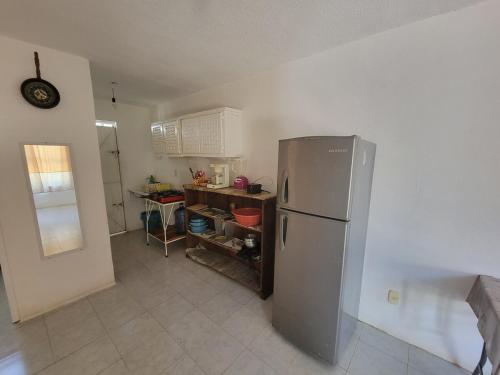 a kitchen with a stainless steel refrigerator and a table at Confort House in Barrio Nuevo
