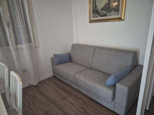 a couch with two blue pillows in a living room at QUEEN HOME Emanuelle in Venice