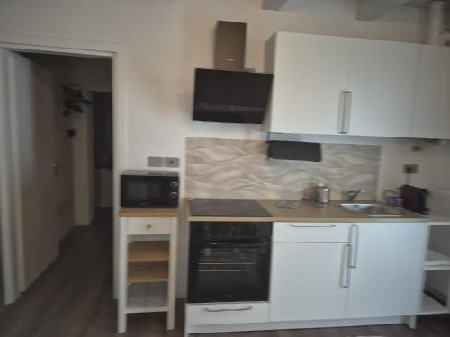 a small kitchen with white cabinets and a sink at QUEEN HOME Emanuelle in Venice